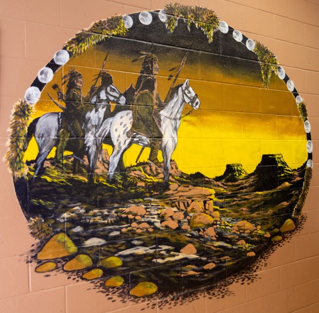 mural on school wall of riders on horses