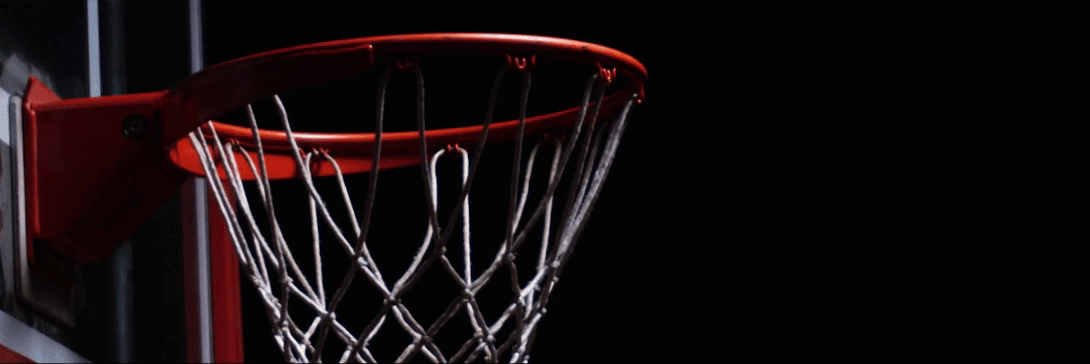 Basketball into goal with warrior logo